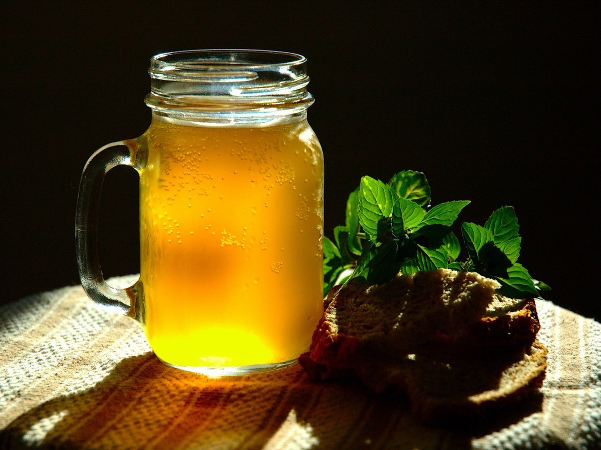 A glass jar of cold kvass with rye bread and mint